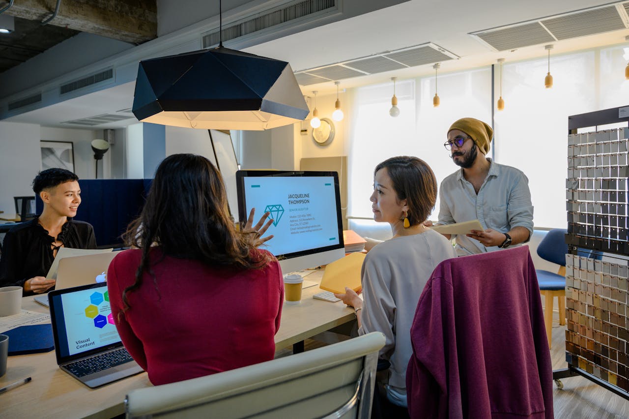 Crafting Captivating Headlines: Your awesome post title goes here A diverse group of professionals working together in a contemporary office setting using laptops and a monitor.